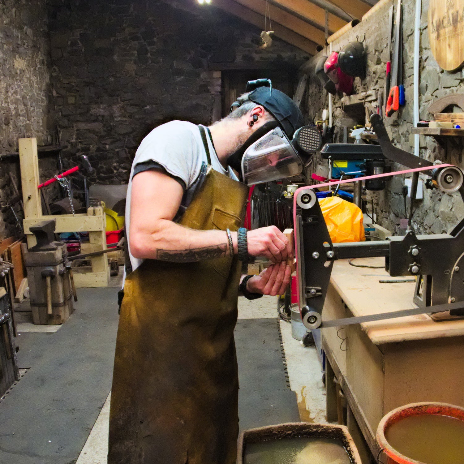 Dave, The Iron Haggis, Standing in front of a belt sander, shaping a knife handle